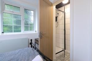 a bedroom with a shower and a bed and a window at Flat 3 Willow Brook in Bedworth