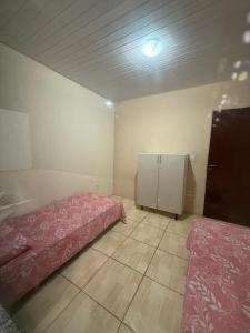 a room with two beds and a refrigerator in it at Ampla Casa Sul da Ilha in Florianópolis +19 photos