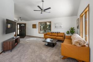 a living room with a couch and a tv at Bobcat Ridge - Mountain Home in Bozeman