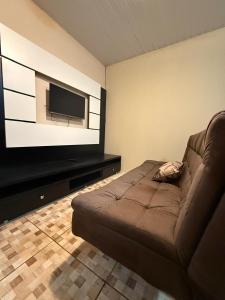 a living room with a couch and a flat screen tv at Ampla Casa Sul da Ilha in Florianópolis