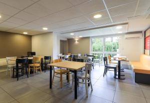 a dining room with tables and chairs and a window at B&B HOTEL Chalon-Sur-Saone Sud in Saint-Rémy +25 photos