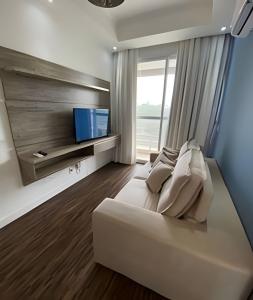 a bedroom with a white couch and a large window at 506 Alphaville Link Studio in Aldeia