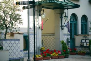 un panneau de rue devant un bâtiment fleuri dans l'établissement Hotel Monterey Nagasaki, à Nagasaki