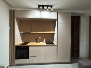 a kitchen with white cabinets and a stove top oven at Montagna Apartments in Kolašin