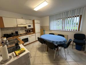 a kitchen with a table and chairs in a kitchen at Apartment DS - Rebberg in Donaueschingen