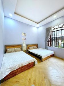 a bedroom with two beds and a window at Sun Home - Gần Cột Cờ Bãi Sau - Free Bida - Karaoke in Vung Tau