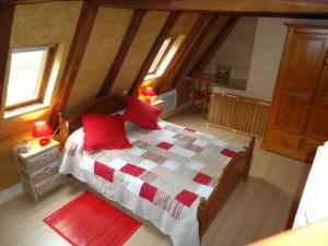 a bedroom with a large bed with red pillows at Gîte de l'Abreuvoir in Vic-sur-Cère