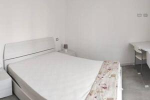 Un dormitorio blanco con una cama y un escritorio. en Rivamare 4 Near the sea, en Andora