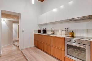 a kitchen with white walls and wooden cabinets at NOCNOC Le Balme in Lyon