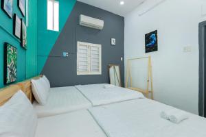 una camera da letto con due letti e una parete blu di SunDay Villa 13 NH - Đi Bộ Ra Biển - Free Bida - Karaoke a Vung Tau