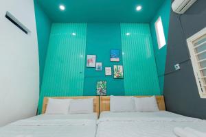 una camera da letto con due letti e una parete verde di SunDay Villa 13 NH - Đi Bộ Ra Biển - Free Bida - Karaoke a Vung Tau Altre 33 foto