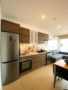 a kitchen with a stainless steel refrigerator and a table at MARESIA APART T0 - Praia do Furadouro in Ovar +11 photos