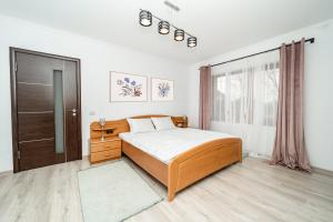 a bedroom with a large bed and a window at Villa cu 4 dormitoare de 3 stele Timiș, perfectă pentru familii sau grupuri in Utvin +53 photos