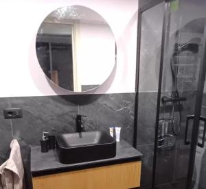 a bathroom with a black sink and a mirror at Bilocale I cervi a pochi passi dalle piste con vista Mondolè in Prato Nevoso +25 photos