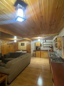 a large living room with a couch and a kitchen at Cabaña AL-YEEN in El Manzano