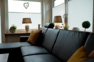 Sofá negro en una sala de estar con 2 lámparas en Ferienwohnungen Citylight Winterberg, en Winterberg