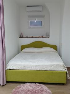 Cama verde en un dormitorio con alfombra rosa en HAPPY HISTORIC HOUSE, en Catania