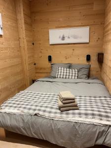 a bed in a wooden cabin with two towels on it at La Foux d 'Allos centre station T4, 7 pers in La Foux