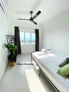 a bedroom with a bed and a ceiling fan at Ulique Homestay Batu Buruk in Kuala Terengganu