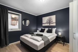 a bedroom with blue walls and a bed and a window at Near Downtown - Large Beds - Free Parking in Tromsø