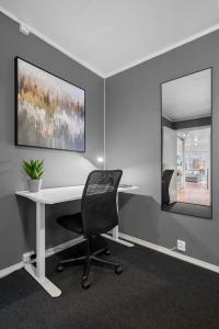 an office with a desk and a chair and a mirror at Near Downtown - Large Beds - Free Parking in Tromsø
