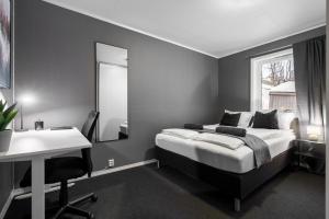 a bedroom with a bed and a desk and a mirror at Near Downtown - Large Beds - Free Parking in Tromsø