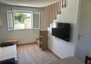 a living room with a flat screen tv on a wall at Appartement piscine Puget-sur-Argens in Puget-sur-Argens