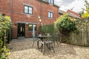a patio with chairs and a table and a fence at Stylish townhouse by the Quay with parking in Exeter