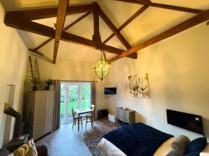 a bedroom with a bed and a table and a chandelier at Beautiful Cotswold Couples Retreat in Bourton on the Water