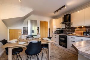 a kitchen with a wooden table and chairs in it at Stylish townhouse by the Quay with parking in Exeter