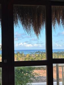 a view of the ocean from a window at Araxá Milagres in São Miguel dos Milagres