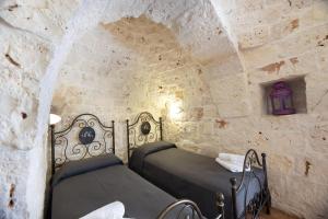 切列梅萨皮卡Villa Acqua Azzurra的一间卧室设有两张石墙床。 更多62张照片