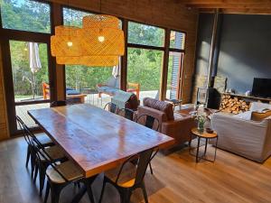 Un comedor con una mesa y una sala de estar. en Peuma Lodge Patagonia, en Futaleufú