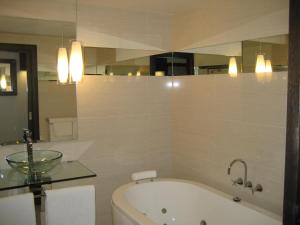 a bathroom with a bath tub and a sink at Gallery Apartments in Warrnambool