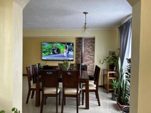 ein Esszimmer mit Tisch und Fernseher in der Unterkunft Casa Condominio la Bahía in Coquimbo