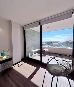 a living room with a chair and a large window at Playa la Boca con vista al mar in Concón