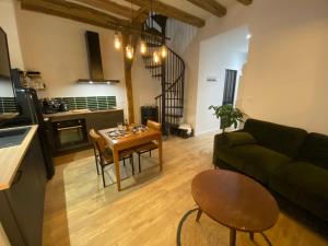 a living room with a couch and a table at L'Oasis Angevine - Balneo, Sauna, Home Cinema & Parking in Angers +26 photos