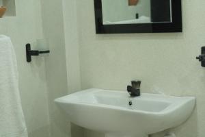 un lavandino bianco in un bagno con uno specchio di Chill house ahangama ad Ahangama