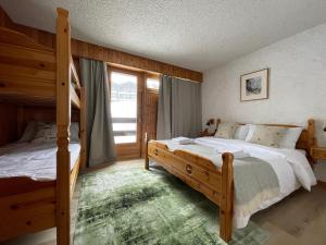 a bedroom with two beds and a large window at Appart La Fouly in La Fouly