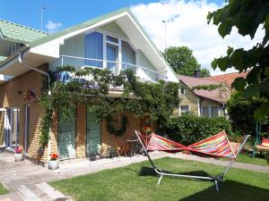 a house with two lawn chairs in the yard at Vila Valdonė in Palanga