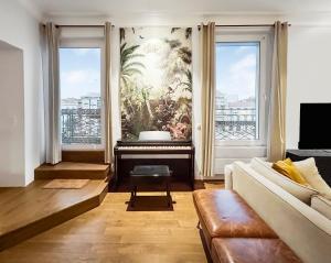 a living room with a couch and a piano at Vue Canal, 3 Suites & Double Salon in Sète