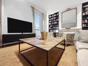 a living room with a table and a television at Vue Canal, 3 Suites & Double Salon in Sète +55 photos