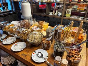a table with plates and bowls of food on it at Best Western Plus Le Conquerant Rouen Nord in Bois-Guillaume