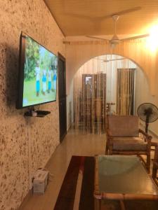 瓦加杜古AMAL HoME的客厅墙上有一台平板电视