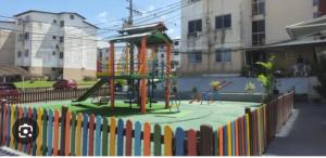 a playground with a slide in front of a fence at Condomínio City Maris in Marituba