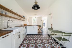 une cuisine avec des armoires blanches et un sol carrelé dans l'établissement Maison entre Port et Calanques, à La Ciotat 11 autres photos