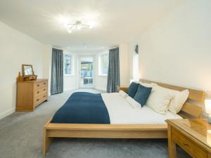 a large bedroom with a large bed and a dresser at Pass the Keys Modern 4-Bed Home Spacious & Comfortable in Pontesbury +48 photos