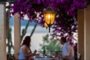 a man and woman sitting at a table under a lamp at Pounda Paou in Metókhion