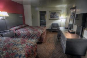 a hotel room with two beds and a television at Driftwood in Santa Clara