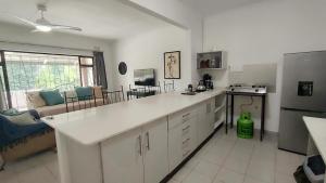 a kitchen with a white counter top and a refrigerator at Pumula on 5th in Pumula